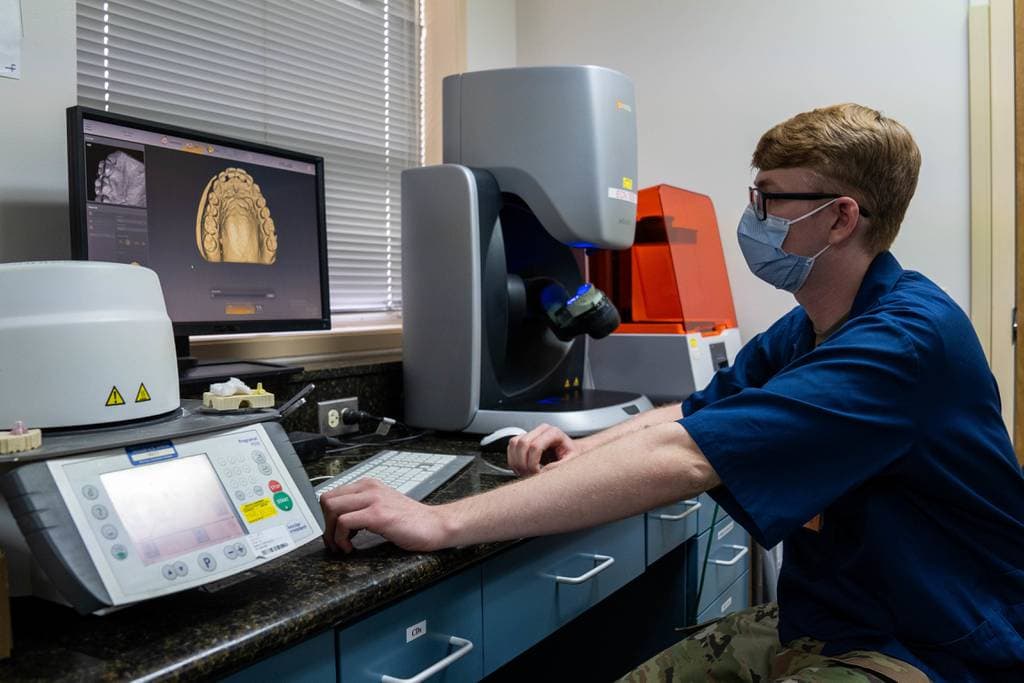 Staff Sgt. Anthony Brown uses software to digitally design a night guard on a digital teeth model. (Airman 1st Class Makensie Cooper/Air Force)