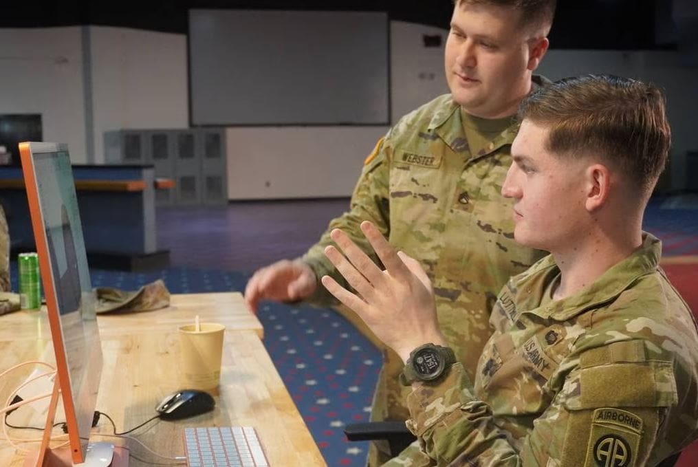 Staff Sgt. Brendan Webster, standing, Additive Manufacturing Lead and instructor, discussing design plans with a specialist who participated in the course. (Army)